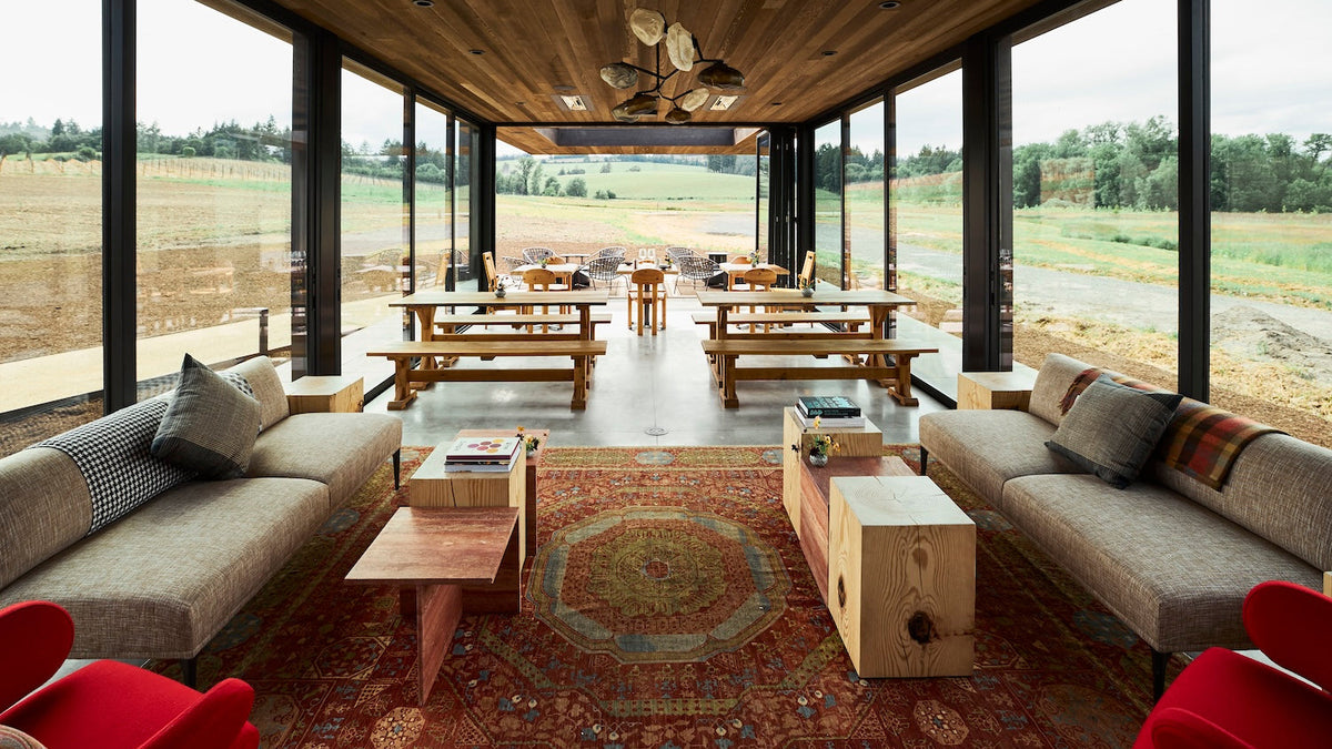 LF tasting room indoor setting with large windows, wooden furniture, and outdoor view.