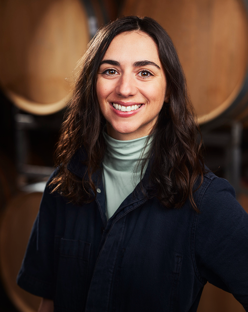 Jaime Bedard Senior Cellar Operator headshot in front of wine barrels
